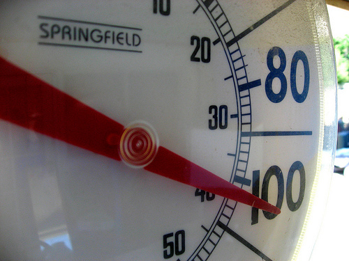 Close up of an outdoor thermometer reading 100 degrees